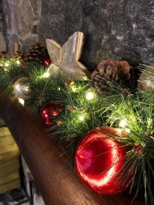 une pièce maîtresse de Noël avec un ornement rouge et des lumières de Noël dans l'établissement Log Cabin, à Kuldīga