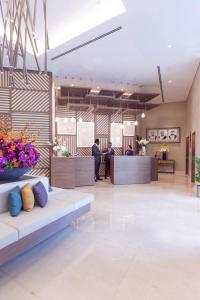 a lobby with couches and flowers in a building at Citadines Culture Village Dubai, Waterfront Jadaf in Dubai