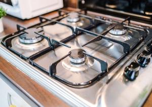 a gas stove top with four burners on it at LUXURY 3 BEDROOM HOUSE Close to Manchester Center in Manchester