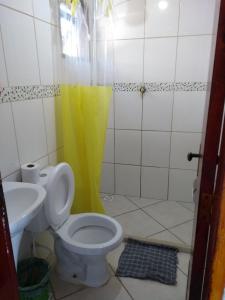 a bathroom with a toilet and a sink at Wando Suítes in Búzios