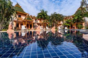 einen Pool in einem Resort mit Stühlen und Bäumen in der Unterkunft Coconut Beach Resort, Koh Chang in Ko Chang