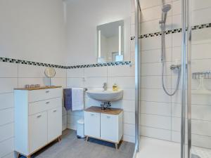 La salle de bains est pourvue d'un lavabo et d'une douche. dans l'établissement Haus Barnheide - Wohnung Sandburg, à Bansin