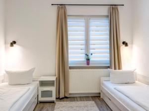 1 Schlafzimmer mit 2 Betten und einem Fenster in der Unterkunft Haus Barnheide - Wohnung Sandburg in Bansin