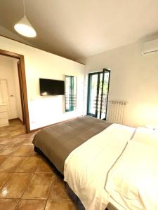 a bedroom with a large bed and a flat screen tv at Le Due Lune in Cesano