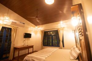 Dānde的住宿－Forest Casa By Rashmiraj - Kashid Beach，一间卧室配有一张床、一张桌子和一台电视。