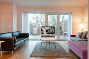 ein Wohnzimmer mit einem Hund auf dem TV in der Unterkunft townhouse on Arlanda Stockholm metro line - easy checkin in Sollentuna