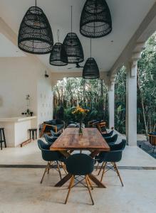 a dining room with a wooden table and chairs at Ambre & Epices Jungle Hotel & Spa in Tulum