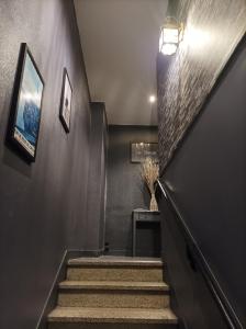 a stairway with a black wall and a stair case at Le Sleepway Lorient in Lorient