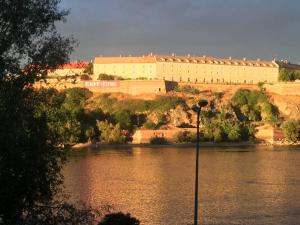 a large building on a hill next to a body of water at Center, Private Garage, Danube & Fortress, 3 bdrm 2 bath in Novi Sad