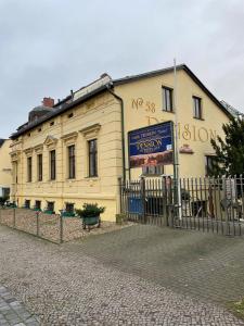 un edificio amarillo con un cartel delante en Pension am Tiefen See, en Potsdam