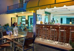 un restaurante con bar, mesas y sillas en Bella Vista Hotel "by Checkin", en Hersonissos