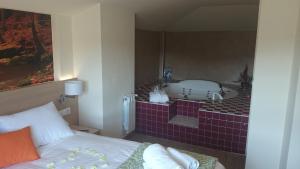 a bedroom with a bathroom with a bath tub at Hostal Rural San Andrés in Torres del Río
