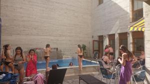 a group of girls standing around a swimming pool at Hostal Rural San Andrés in Torres del Río