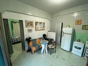 een keuken met een bank, een tafel en een koelkast bij Kitnet Praia do Trapiche in Penha