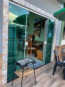 um pátio com uma mesa, cadeiras e um guarda-sol em Kitnet Praia do Trapiche em Penha