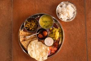 une assiette contenant différents types de denrées alimentaires sur une table dans l'établissement Forest Casa By Rashmiraj - Kashid Beach, à Dānde