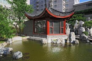 a small building in the middle of a pond at Hotel New Otani Chang Fu Gong in Beijing