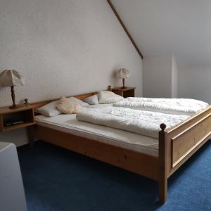 a bedroom with a bed with two nightstands and two lamps at Ferienwohnungen Kupferkanne in Todtmoos