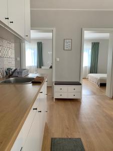 a white kitchen with a sink and a bedroom at Otthon a Balatonon Vendégház in Keszthely