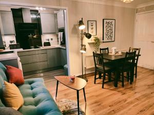uma sala de estar com um sofá, uma mesa e uma cozinha em City Centre Apartment- Beautiful Old Town- with Parking em Hull