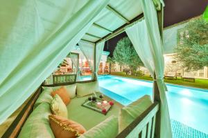 a living room with a couch next to a swimming pool at Kose Konak Butik Hotel-Special in Alacati