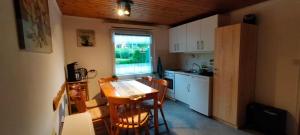 a kitchen with a table and chairs and a window at Ferienhaus Rana in Wolfshagen