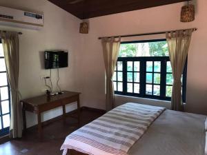 um quarto com uma cama, uma secretária e uma janela em Forest Casa By Rashmiraj - Kashid Beach em Dānde
