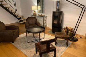 sala de estar con sillas, mesa y chimenea en Sumptuous Cap Ferret Style House, en La Teste-de-Buch