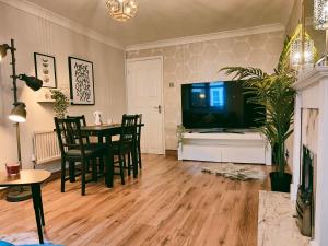 sala de estar con TV, mesa y sillas en City Centre Apartment- Beautiful Old Town- with Parking en Hull