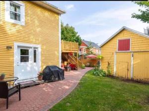 a yard with a yellow house and a patio at Sunny Home B&B in Charlottetown