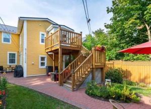 a large wooden deck in a yard next to a house at Sunny Home B&B in Charlottetown