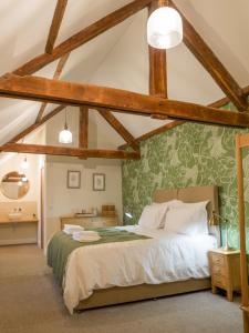 ein Schlafzimmer mit einem Bett mit einer grünen Wand in der Unterkunft Coach House Ratho Park Steading in Ratho