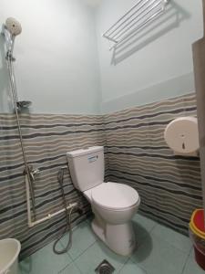 a bathroom with a toilet and a sink at DJCI Apartelle Small Rooms in Cabanatuan