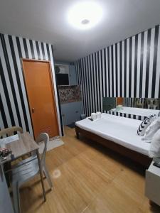 a bedroom with a large bed and a table at DJCI Apartelle Small Rooms in Cabanatuan