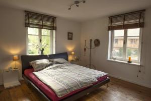 a bedroom with a bed and two windows at 5 Sterne FeWo mit Garten und Bergblick in Chiemsee-Nähe in Übersee