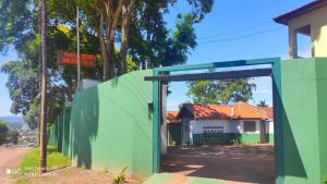 a green wall with a door in front of a house at Pousada Recanto das Maritacas in Brotas
