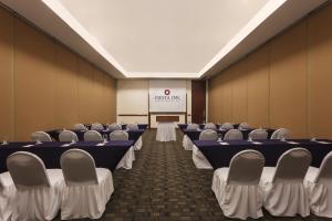 a conference room with tables and chairs and a screen at Fiesta Inn Veracruz Boca Del Rio in Veracruz