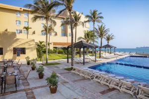 un complexe avec une piscine et des palmiers dans l'établissement Fiesta Inn Veracruz Boca Del Rio, à Veracruz