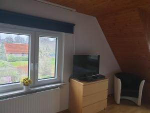 a living room with a tv and a window at Ferienhaus 3119 in Tossens in Butjadingen OT Tossens