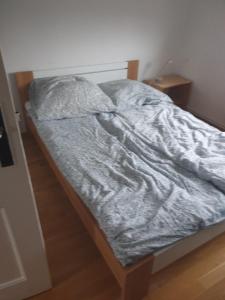 an unmade bed in a bedroom with a night stand at Ferienhaus 3119 in Tossens in Butjadingen OT Tossens