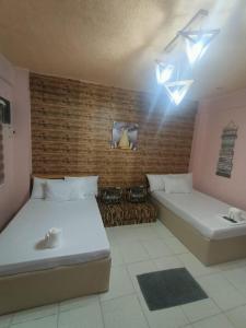 1 Schlafzimmer mit 2 Betten und Ziegelwand in der Unterkunft DJCI Apartelle with own bath & kitchen 101-211 in Cabanatuan