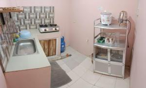 a small kitchen with a sink and a stove at DJCI Apartelle Walk to Robinson & NE Pacific Mall 3 Min to SM Cabanatuan in Cabanatuan