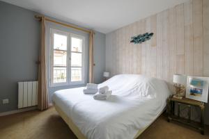 a bedroom with a white bed and a window at Sur l'ilot, au centre du port, vue UNIQUE ! in Saint-Martin-de-Ré