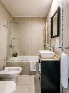 a bathroom with a sink and a toilet and a tub at La Vela in Ushuaia