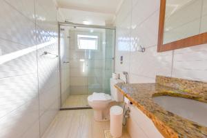 a bathroom with a shower and a toilet and a sink at Pousada Viena in Gramado