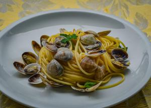 a plate of pasta with clams on a table at Hotel Stradiot in Rimini
