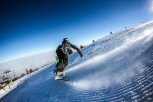 una persona montando una tabla de snowboard por una pendiente cubierta de nieve en Studios -Villa Park SV, en Borovets