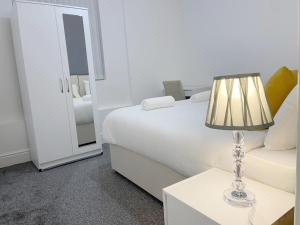 a bedroom with a bed and a lamp on a table at New Brighton Flat in Wallasey