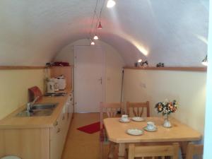 eine kleine Küche mit einem Tisch und einem Waschbecken in der Unterkunft Appartements im Forsthaus in Strobl
