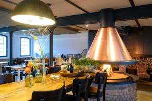 a dining room with a large bell hanging over a table at Hotel Gut Immenhof in Malente